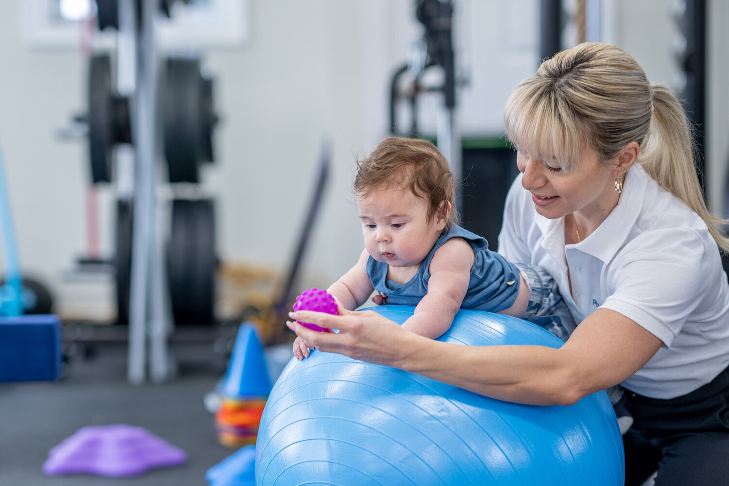 Occupational therapist supporting a child on an exercise ball